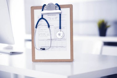 Stetoskop ve ilaç geçmişi olan dosya doktorların çalışma yerinde masanın üstünde. İlaç ve sağlık hizmetleri kavramı.