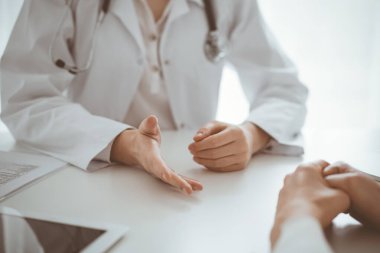 Doktor ve hasta klinikteki masada otururken sağlık sorularını tartışıyorlar. Kapatıyorlar. Tıp ve sağlık hizmetleri kavramı.