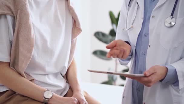 Doktor Hasta Yanında Otururken Tablet Bilgisayar Kullanıyor Bilinmeyen Kıdemli Doktor — Stok video