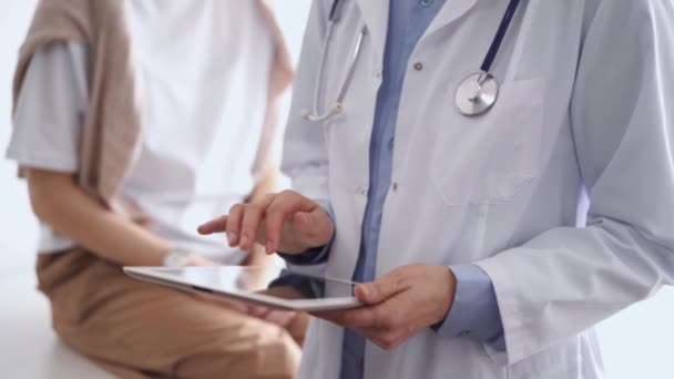 病人坐在旁边时 医生正在用平板电脑 不知名的资深医生在工作 医药和保健概念 — 图库视频影像