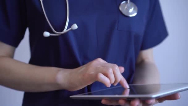 博士女士站在灰蒙蒙的背景下 用平板电脑 靠得很近 医生或外科医生在工作 医学概念 — 图库视频影像