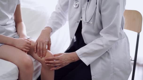 Lekarz Pacjent Klinice Ortopeda Białym Płaszczu Bada Staw Kolanowy Dziewczynki — Wideo stockowe