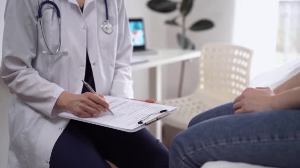 Lekarz Pacjent Siedzący Naprzeciwko Siebie Klinice Zbliżenie Nieznana Lekarka Używająca — Wideo stockowe