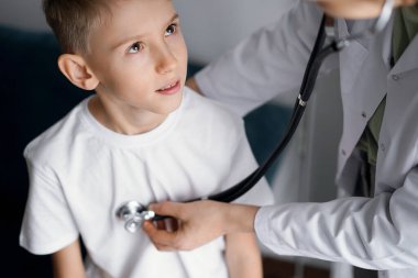 Doktor ve çocuk evde. Çocuk hasta her zamanki sağlık kontrolünde. Tıp, sağlık hizmetleri kavramları.