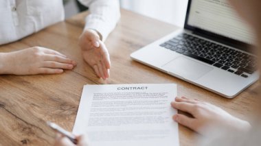 Ofisteki ahşap masada otururken sözleşmeyi imzalayan işadamları, yakın plan. Toplantıda ortaklar ya da avukatlar birlikte çalışıyor. Takım çalışması, ortaklık, başarı kavramı.