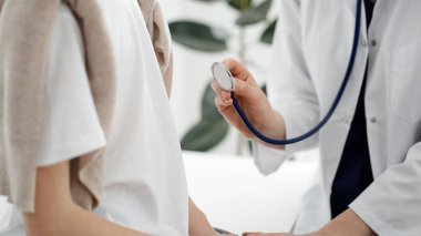 Doktor ve bir çocuk hasta. Doktor steteskop tutuyor ve çocuğu muayene etmeye hazır. Tıpta mükemmel sağlık kavramı.