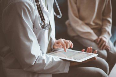 Doktor kadın ve çocuk hasta muayene odasında, steteskop yakın çekim. Tablet bilgisayar kullanan çocuk doktoru, kapatın. Tıp, sağlık hizmetleri kavramları.