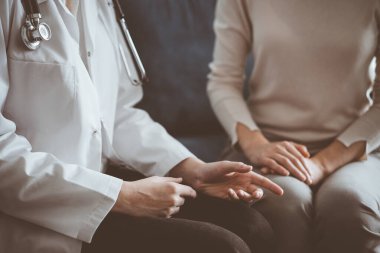 Doktor ve hasta klinikteki kanepede otururken sağlık muayenesini tartışıyorlar. Tıp konsepti.