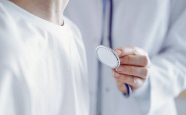 Bilinmeyen doktor ve çocuk hasta her zamanki sağlık kontrolünde. Hekim steteskop kullanıyor, yakın çekim. Tıp, sağlık hizmetleri kavramları.