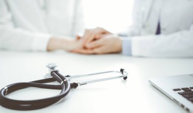 Stetoskop, bir doktor ve hastanın yanında oturan tabletin bilgisayarında duruyordu. Tıp, güven veren eller konsepti.