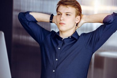 Genç sarışın işadamı ve programcı karanlık bir ofiste bilgisayarla sıkı çalıştıktan sonra el ele tutuşuyor, arka planda ışık parlıyor..