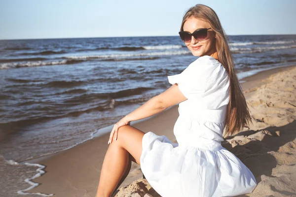 Šťastná Krásná Blondýna Žena Sedí Pláži Oceánu Bílých Letních Šatech — Stock fotografie
