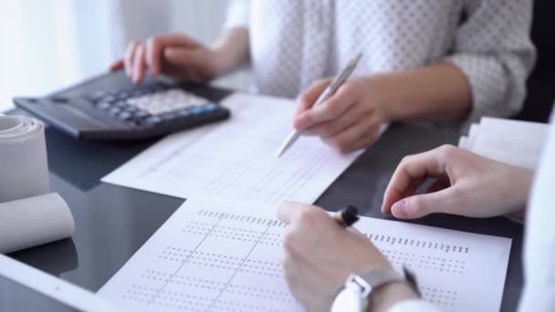 两名会计师使用笔记本电脑和计算器在办公室的白色桌子上计算税款 业务审计和财务方面的团队合作 — 图库视频影像