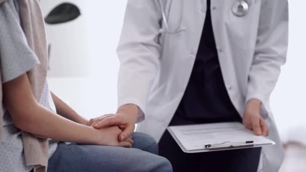 Orvos Megnyugtatja Gyerekbeteget Miközben Mindketten Ülnek Beszélgetnek Egymással Szemben Együttérzés — Stock videók
