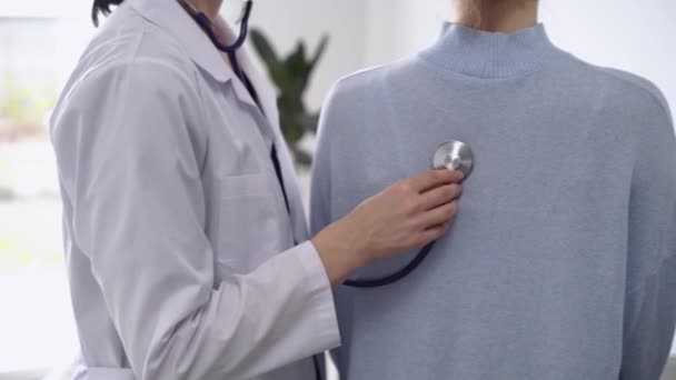 의사와 환자는 병원에 있어요 코트를 스테로스코프로 여성을 클로즈업 — 비디오