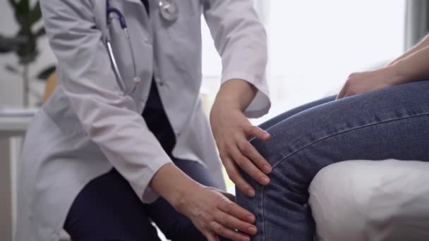 Lekarz Pacjent Klinice Ortopeda Białym Płaszczu Bada Staw Kolanowy Kobiety — Wideo stockowe