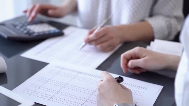 两名会计师使用笔记本电脑和计算器在办公室的白色桌子上计算税款 业务审计和财务方面的团队合作 — 图库视频影像
