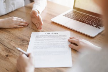 Ofisteki ahşap masada otururken sözleşmeyi imzalayan işadamları, yakın plan. Toplantıda ortaklar ya da avukatlar birlikte çalışıyor. Takım çalışması, ortaklık, başarı kavramı.