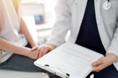 Doktor ve çocuk hasta. Hekim elinde bir dosya tutuyor ve bir çocuğu rahatlatıyor. Tıptaki ideal sağlık kavramı.