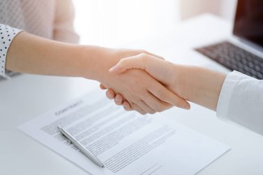 İş adamları anlaşma kağıtlarının üzerinde el sıkışıyorlar. Beyaz masaya yeni imzalanmış, yakın plan. Toplantıdaki avukatlar. Takım çalışması, ortaklık, başarı kavramı.