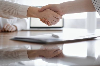 İş adamları kontrat kağıtlarının üzerinde el sıkışıyor. Tahta masaya yeni imzalanmış. Kapatın. Toplantıdaki avukatlar. Takım çalışması, ortaklık, başarı kavramı.