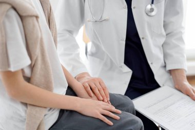 Doktor ve çocuk hasta. Hekim elinde bir dosya tutuyor ve bir çocuğu rahatlatıyor. Tıptaki ideal sağlık kavramı.