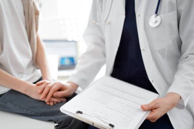 Doktor ve çocuk hasta. Hekim elinde bir dosya tutuyor ve bir çocuğu rahatlatıyor. Tıptaki ideal sağlık kavramı.