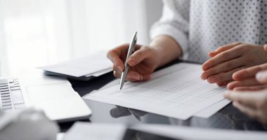 Müşteri ile vergileri sayıp tartışırken hesap makinesi ve dizüstü bilgisayar kullanan kadın muhasebeci. İş denetimi ve finans kavramları.