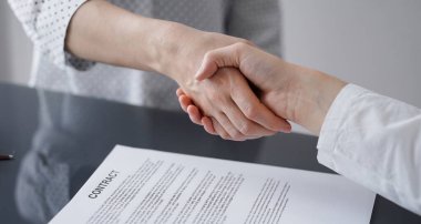 Ofisteki cam masada otururken sözleşmeyi imzalayan işadamları, yakın plan. Toplantıda ortaklar ya da avukatlar birlikte çalışıyor. Takım çalışması, ortaklık, başarı kavramı.