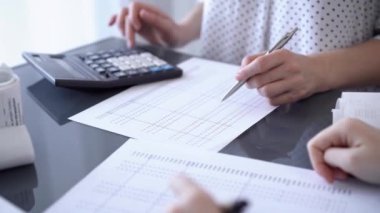 Kadın muhasebeci vergileri sayıyor ya da bir müşteri için gelir dengesi kuruyor. İş denetimi ve finans kavramları.