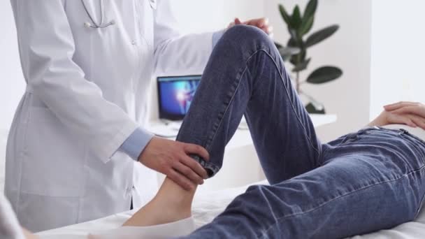 의사와 환자는 병원에서 일반적인 검사에 있습니다 치료사는 무릎을 검사합니다 — 비디오
