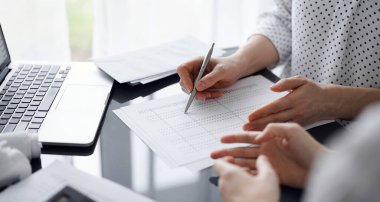 Müşteri ile vergileri sayıp tartışırken hesap makinesi ve dizüstü bilgisayar kullanan kadın muhasebeci. İş denetimi ve finans kavramları.