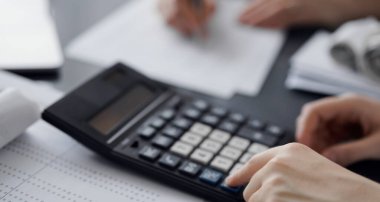 Müşteri için vergi sayarken hesap makinesi ve dizüstü bilgisayar kullanan kadın muhasebeci. İş denetimi ve finans kavramları.