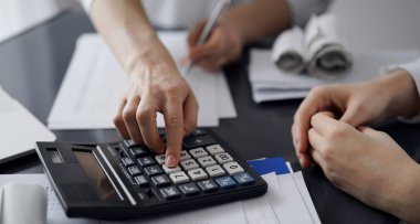 Müşteri için vergi sayarken hesap makinesi ve dizüstü bilgisayar kullanan kadın muhasebeci. İş denetimi ve finans kavramları.