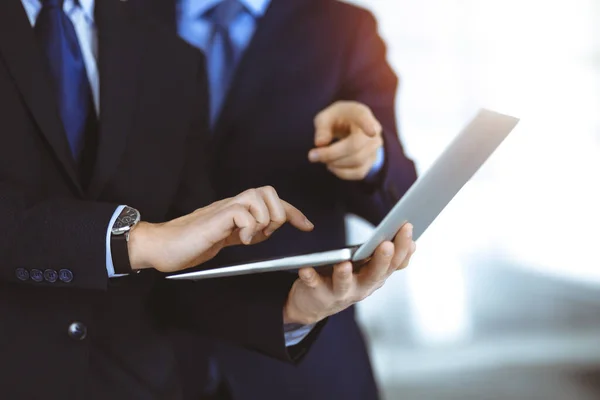 İş adamları, güneşli ve modern bir ofiste toplantının sunumunu tartışıyor. Meslektaşı ile birlikte bilinmeyen işadamı laptopta bazı bilgiler arıyor, avukatlar görüşmede.