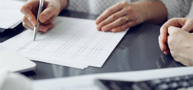 Müşteri için vergi sayarken hesap makinesi ve dizüstü bilgisayar kullanan kadın muhasebeci. İş denetimi ve finans kavramları.