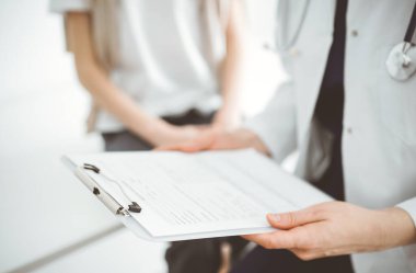 Doktor ve çocuk hasta. Hekim elinde bir çocuğun yanında ilaç geçmişi olan bir dosya tutuyor. Tıptaki ideal sağlık kavramı.