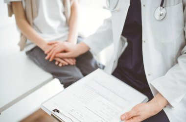 Doktor ve çocuk hasta. Hekim elinde bir dosya tutuyor ve bir çocuğu rahatlatıyor. Tıptaki ideal sağlık kavramı.