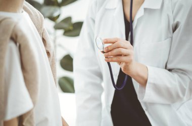 Doktor ve bir çocuk hasta. Doktor steteskop tutuyor ve çocuğu muayene etmeye hazır. Tıpta mükemmel sağlık kavramı.