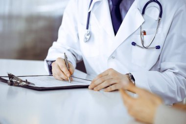 Bilinmeyen erkek doktor ve hasta kadın klinikte oturup dosya kullanırken bir şey tartışıyorlar. Hastanedeki en iyi sağlık hizmeti, ilaç, salgın durdurma..