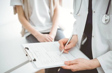 Doktor ve çocuk hasta. Hekim bir çocuğun yanında pano tutuyor ve tıbbi kayıt formunda yazıyor. Tıptaki ideal sağlık kavramı.