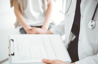 Doktor ve çocuk hasta. Hekim elinde bir dosya tutuyor ve bir çocuğu rahatlatıyor. Tıptaki ideal sağlık kavramı.