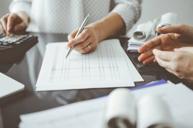 Müşteri ile vergileri sayıp tartışırken hesap makinesi ve dizüstü bilgisayar kullanan kadın muhasebeci. İş denetimi ve finans kavramları.