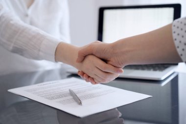 İş adamları sözleşme kağıtlarının üzerinde el sıkışıyorlar. Gri masaya yeni imzaladılar. Kapatın. Avukatlar ya da girişimciler toplantıda. Takım çalışması, ortaklık, başarı kavramı.