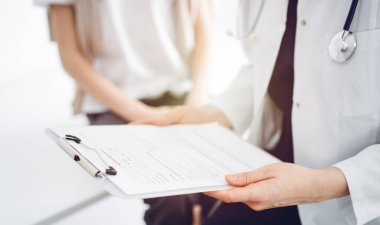 Doktor ve çocuk hasta. Hekim elinde bir çocuğun yanında ilaç geçmişi olan bir dosya tutuyor. Tıptaki ideal sağlık kavramı.