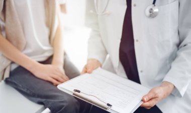 Doktor ve çocuk hasta. Hekim elinde bir çocuğun yanında ilaç geçmişi olan bir dosya tutuyor. Tıptaki ideal sağlık kavramı.