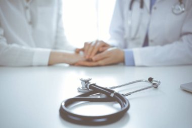 Stetoskop, bir doktor ve hastanın yanında oturan tabletin bilgisayarında duruyordu. Tıp, güven veren eller konsepti.