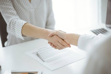 İş adamları anlaşma kağıtlarının üzerinde el sıkışıyorlar. Beyaz masaya yeni imzalanmış, yakın plan. Toplantıdaki avukatlar. Takım çalışması, ortaklık, başarı kavramı.