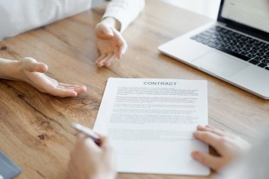 Ofisteki ahşap masada otururken sözleşmeyi imzalayan işadamları, yakın plan. Toplantıda ortaklar ya da avukatlar birlikte çalışıyor. Takım çalışması, ortaklık, başarı kavramı.