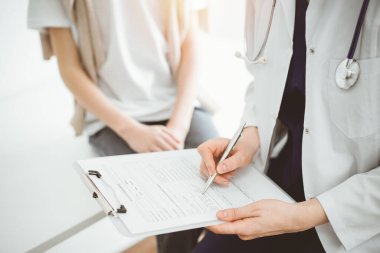 Doktor ve çocuk hasta. Hekim bir çocuğun yanında pano tutuyor ve tıbbi kayıt formunda yazıyor. Tıptaki ideal sağlık kavramı.